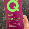 Hand holding a purple PurQ Gut Care supplement box with green text and logo, containing Queen Garnet Powder with Pre+Probiotic in 15 sachets