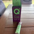 PurQ Gut Care supplement box and packet on wooden table outdoors
