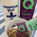 A bowl of cereal with milk carton and supplement boxes on a striped surface