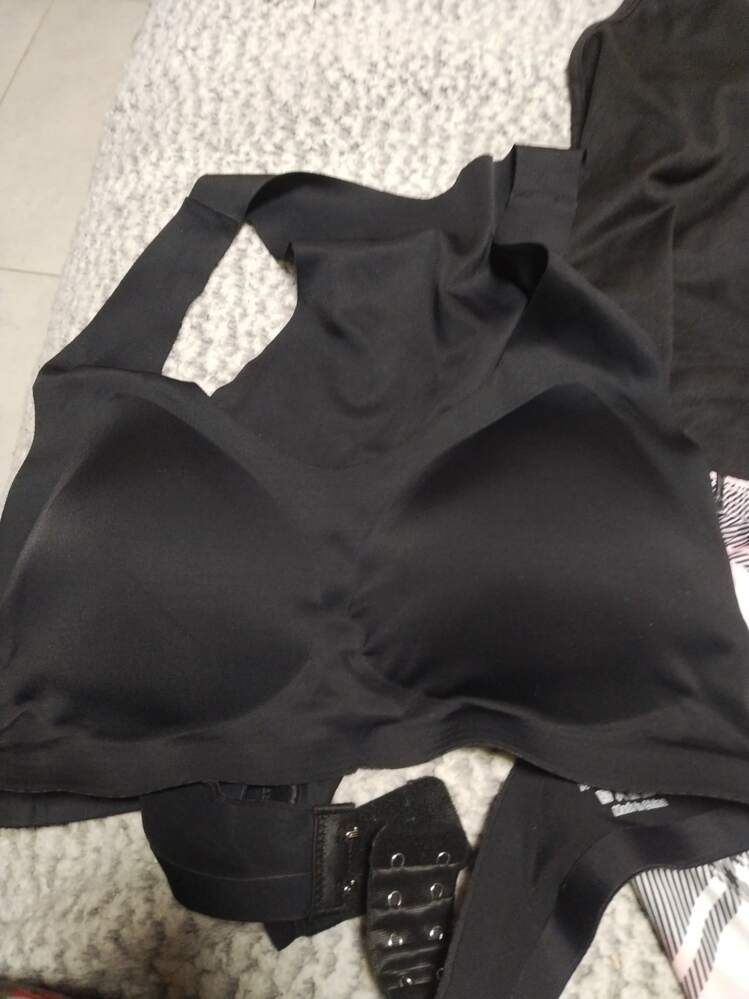 Black clothing items laid out on a white textured surface