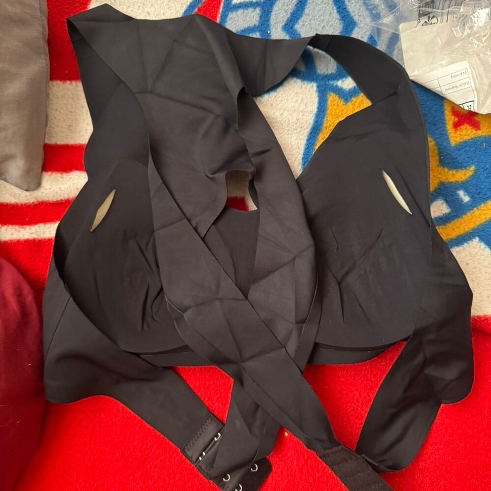 Black clothing items laid out on a colorful striped blanket or rug