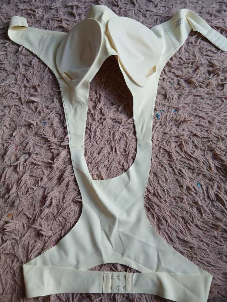 A cream-colored undergarment laid flat on a textured purple carpet or rug