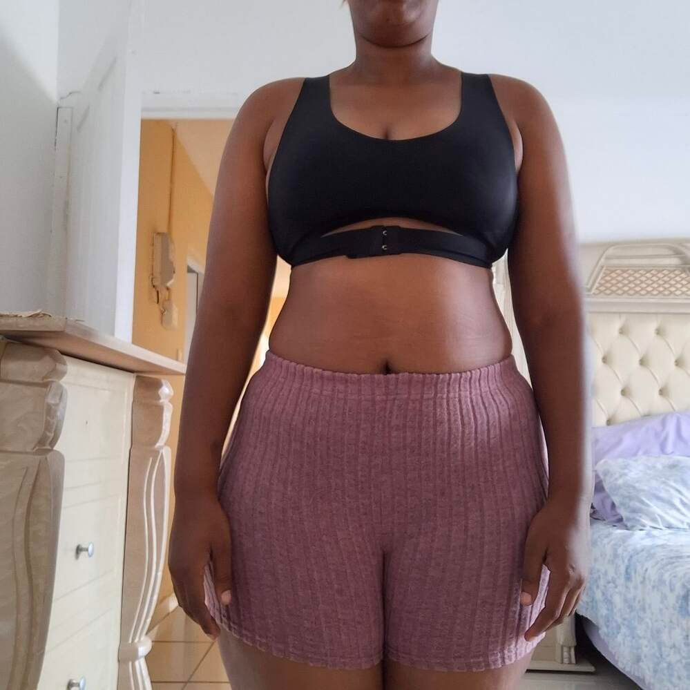 Person wearing casual athletic wear standing in a bedroom