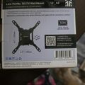 Low-Profile Tilt TV Wall Mount packaging box showing product specifications, compatibility details for 13-50 inch TVs, mounting dimensions, VESA standards, barcode, and QR code for additional information.