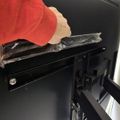 Person wearing red gloves placing aluminum foil on an oven rack