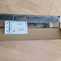Unboxed furniture hardware including metal rails and assembly instructions on wooden floor