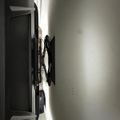 A flat-screen TV mounted on a white wall with an adjustable wall mount bracket