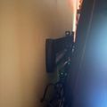 Electronic device with green LED lights mounted on wall in dimly lit room