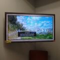 Wall-mounted TV displaying a "No Signal" error message over a landscape background image