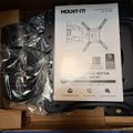 Mount-It brand TV wall mount kit with installation manual and hardware components in packaging
