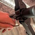 Person's hand operating a mechanical lever or handle on what appears to be exercise equipment or machinery