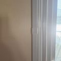 Interior view showing white door frame and trim against a beige wall with natural light coming through a window