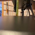Person measuring height of equipment with yellow measuring tape in workshop setting
