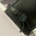 Black monitor on desk with headphones and cables