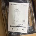 Installation manual for a Mount-It heavy-duty clamp-on CPU mount in an open shipping box with plastic packaging
