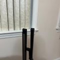Black metal crutches leaning against white wainscoting on a wall in a home interior