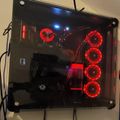 Gaming PC with transparent side panel showing red LED cooling fans and internal components