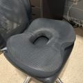 Gray ergonomic seat cushion with center cutout placed on black office chair