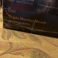 Package for a Mount-It triple monitor mount with gas spring arms on a textured surface