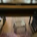 Blurry interior view of what appears to be a kitchen area with cabinets and appliances underneath a counter or workspace
