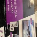 Product packaging for an In-Wall TV Cable Concealer Kit showing before and after installation photos and mounting hardware