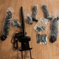 Various black electronic components and accessories laid out on a wooden floor, some still in plastic packaging