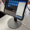 Point of sale tablet display showing restaurant ordering system with menu items and payment options on counter