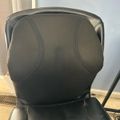 Black office chair with mesh backrest and leather seat, viewed from behind