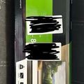 Package for a full-motion TV wall mount with green and black product labeling and mounting hardware visible