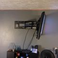Living room with wall-mounted TV, wooden display cabinets, and entertainment center below television