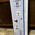 Package for a heavy-duty XXL tilt TV wall mount showing installation diagrams and product specifications on a wooden surface
