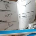 Installation manual showing steps for mounting channels to wall and routing cables, with diagrams illustrating adhesive backing application and screw anchor options