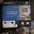 Mount-It low-profile tilt TV wall mount package for 13-50 inch TVs, model MI-203TXL, showing product box with mounting bracket and specifications including 20kg weight capacity and VESA compatibility.