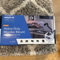 A boxed Mount-It! ProFlex Series heavy-duty monitor mount with gas spring arm for 17-49 inch screens, sitting on a textured rug next to hardwood flooring
