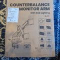 Cardboard box for a MOUNT-IT counterbalance monitor arm with RGB lighting, showing product diagram and specifications on packaging