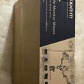 A cardboard box for a triple gas monitor mount with spring arms, showing product packaging and assembly diagram