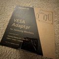 VESA adapter packaging for Samsung monitors with cardboard mounting template on carpet