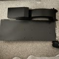 Black exercise equipment or rowing machine on carpeted floor next to furniture