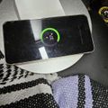Smartphone charging wirelessly on white charging pad showing 31% battery level with green charging indicator