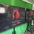 A large TV screen displaying a movie poster for "Nosferatu" with red and black graphics, set up in a room with green walls and musical equipment