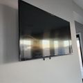 Large flat-screen TV mounted on white wall in modern interior room
