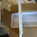 White furniture assembly pieces and hardware laid out on cardboard packaging with instruction materials