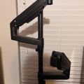Black adjustable monitor arm mounted on desk with articulating joints and clamp base