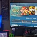 Gaming setup with two monitors displaying video games and a game library interface