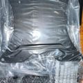 Inflatable gray chair or cushion in clear plastic packaging with instruction materials