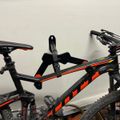 Black and orange mountain bike with suspension fork and knobby tires displayed indoors