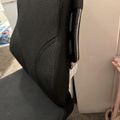 Black office chair with mesh back and fabric seat positioned next to a white wall