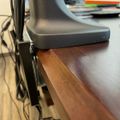 Gray plastic chair positioned at edge of wooden desk or table surface