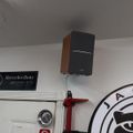 Interior wall with Mercedes-Benz AMG sign, mounted speaker, and partial view of Jaguar logo