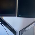 Dual monitor setup on adjustable desk mount with white desk surface